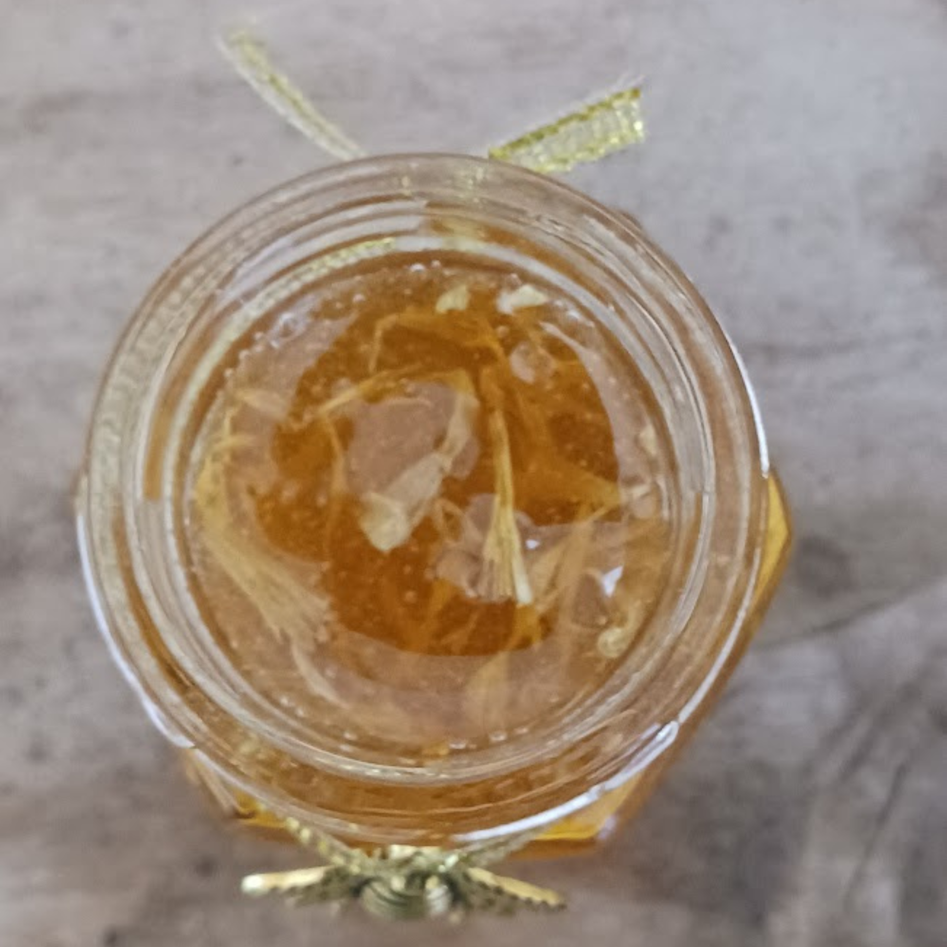 Top view of Calendula Glow Honey showing organic calendula petals floating in raw honey